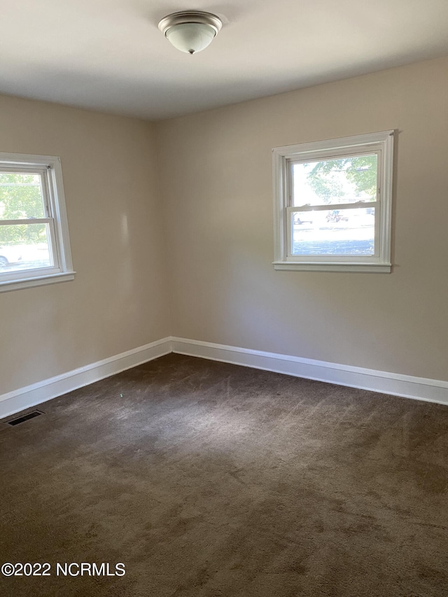 empty room with dark colored carpet