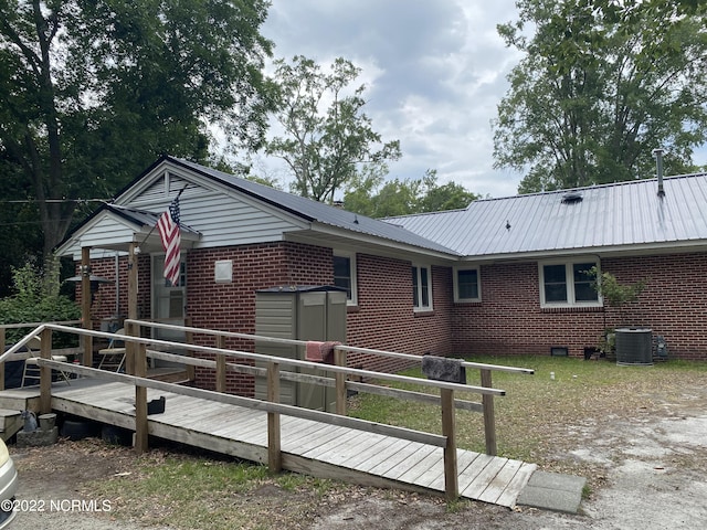 rear view of house featuring a shed, central AC, and a deck