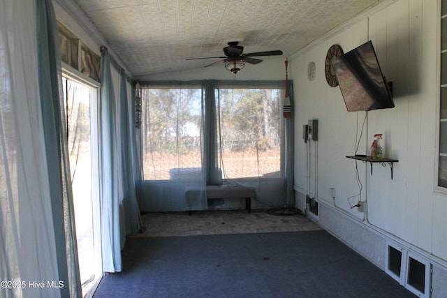 unfurnished sunroom featuring lofted ceiling, ceiling fan, and a healthy amount of sunlight