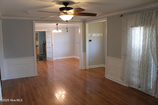 unfurnished room featuring crown molding, ceiling fan with notable chandelier, and dark wood-type flooring