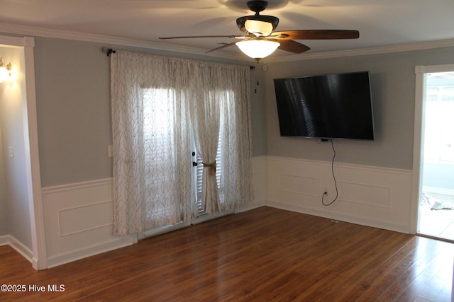 empty room featuring crown molding, dark wood-type flooring, and ceiling fan