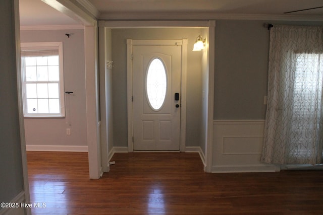 entrance foyer with ornamental molding and dark hardwood / wood-style floors