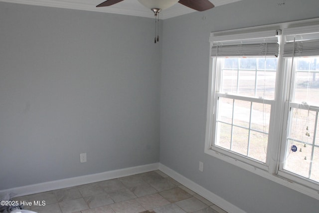 empty room featuring ceiling fan, plenty of natural light, tile patterned floors, and ornamental molding