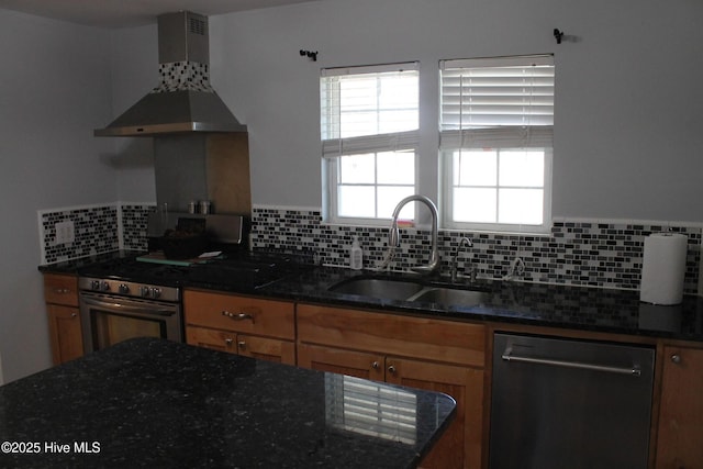 kitchen featuring sink, dark stone countertops, stainless steel appliances, range hood, and backsplash