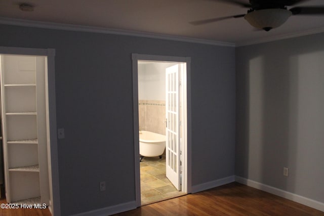 unfurnished bedroom featuring hardwood / wood-style flooring, crown molding, connected bathroom, and ceiling fan