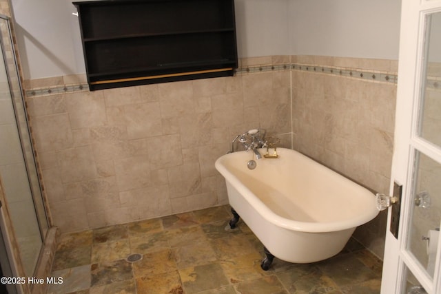 bathroom featuring tile walls and shower with separate bathtub