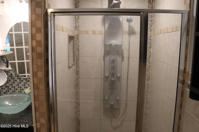 bathroom featuring vanity, decorative backsplash, and walk in shower