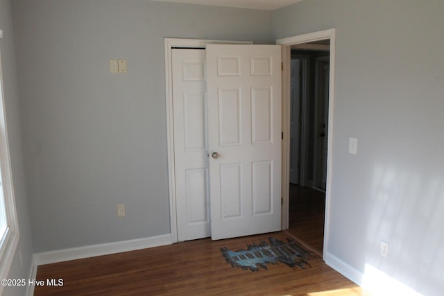 unfurnished bedroom featuring dark hardwood / wood-style floors and a closet