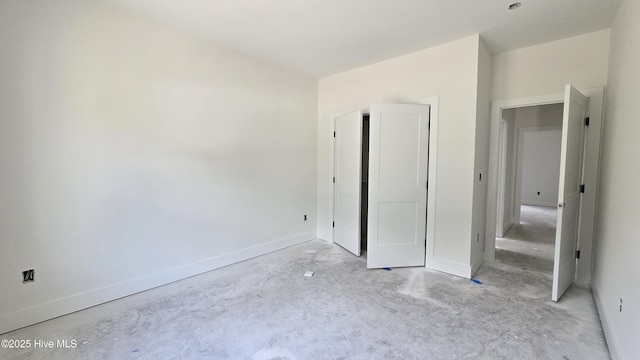 unfurnished bedroom featuring baseboards and concrete floors
