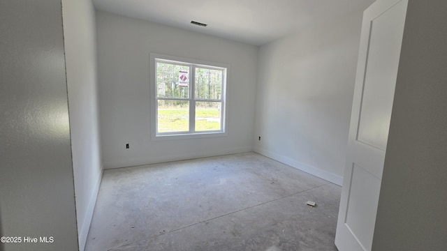 unfurnished room with baseboards, visible vents, and unfinished concrete flooring