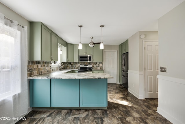 110 NE 29th St, Oak Island, NC 28465 - kitchen with appliances with stainless steel finishes, green cabinets, a peninsula, stone finish floors, and tasteful backsplash