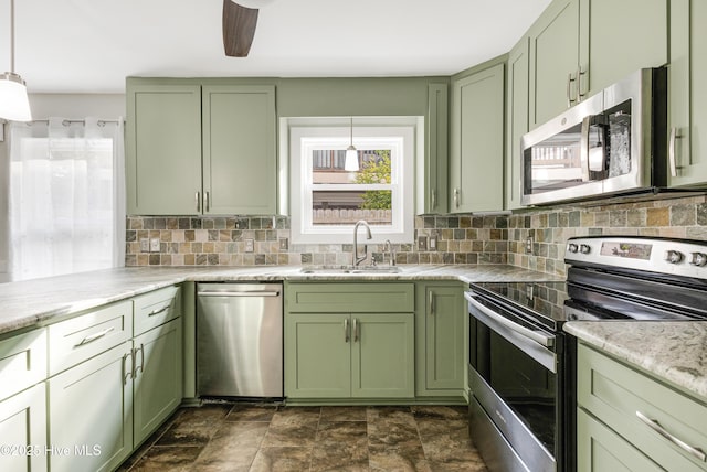 110 NE 29th St, Oak Island, NC 28465 - kitchen featuring green cabinets, stainless steel appliances, tasteful backsplash, and hanging light fixtures