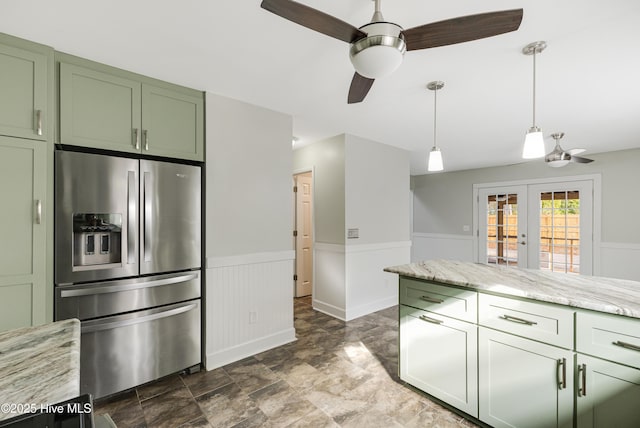 110 NE 29th St, Oak Island, NC 28465 - kitchen with stainless steel fridge with ice dispenser, green cabinets, ceiling fan, a wainscoted wall, and french doors