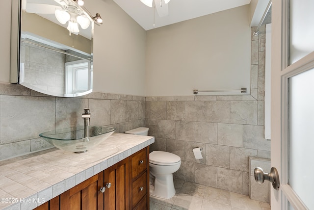 bathroom featuring tile walls, vanity, ceiling fan, tile patterned floors, and toilet