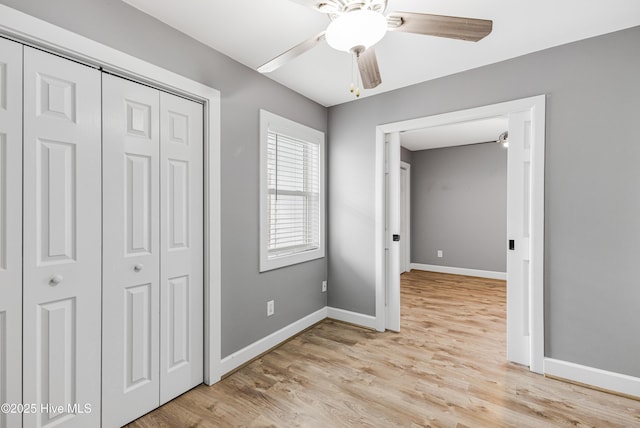 110 NE 29th St, Oak Island, NC 28465 - unfurnished bedroom with a closet, light wood-style flooring, and a ceiling fan