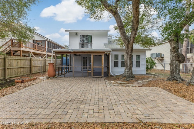 110 NE 29th St, Oak Island, NC 28465 - back of property featuring a sunroom, a patio, and a fenced backyard