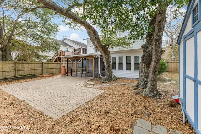 view of yard featuring a fenced backyard, a patio, and a sunroom