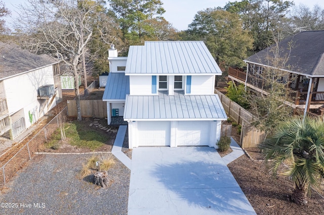 110 NE 29th St, Oak Island, NC 28465 - view of front of property with a metal roof, a chimney, concrete driveway, and a garage