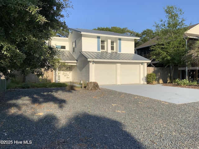 110 NE 29th St, Oak Island, NC 28465 - traditional-style house with a standing seam roof, a metal roof, an attached garage, and driveway