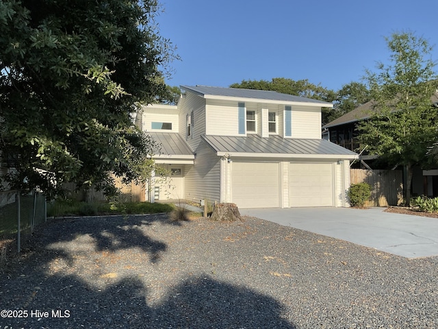 110 NE 29th St, Oak Island, NC 28465 - view of front of property featuring a standing seam roof, a metal roof, a garage, and driveway