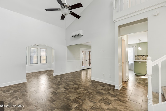 110 NE 29th St, Oak Island, NC 28465 - spare room featuring an AC wall unit, high vaulted ceiling, ceiling fan, a smoke detector, and arched walkways