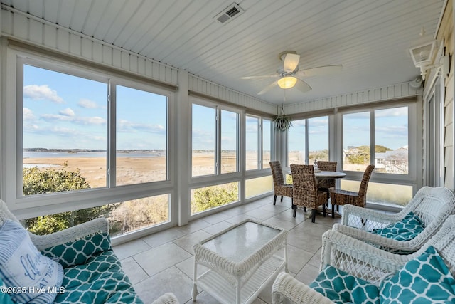 sunroom featuring a water view and ceiling fan