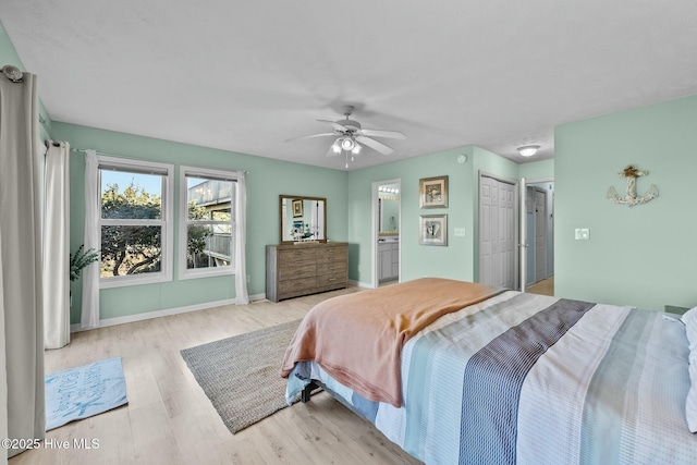 bedroom featuring ceiling fan, ensuite bathroom, and light wood-type flooring