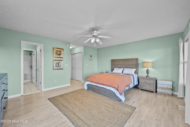 bedroom with light hardwood / wood-style floors, a closet, ceiling fan, and ensuite bathroom