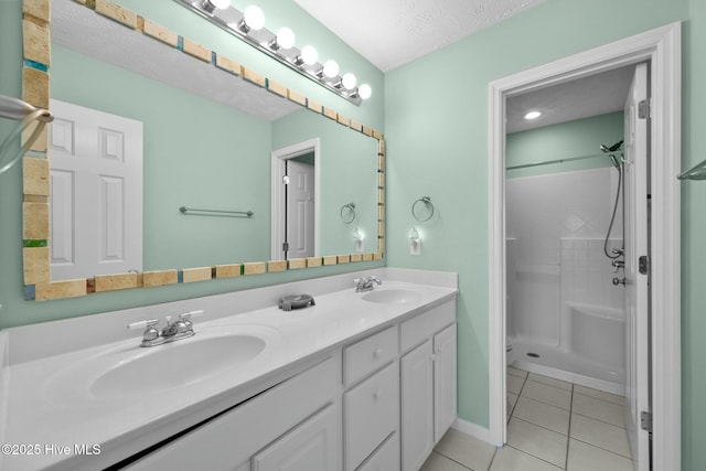 bathroom featuring tile patterned flooring, a shower, vanity, and a textured ceiling