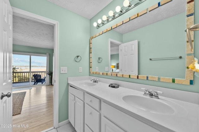 bathroom featuring vanity, hardwood / wood-style floors, and a textured ceiling