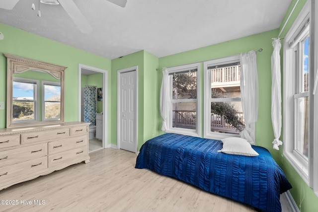 bedroom featuring ensuite bath, light hardwood / wood-style flooring, and ceiling fan