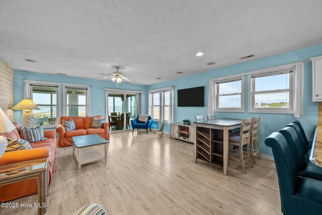 bedroom featuring access to exterior, a textured ceiling, light hardwood / wood-style floors, and ceiling fan