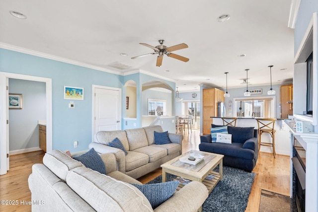 living room featuring crown molding, ceiling fan, and light wood-type flooring