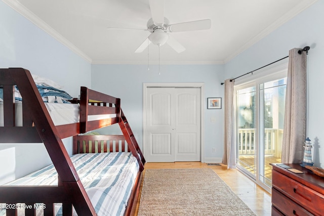 bedroom featuring access to exterior, crown molding, a closet, and light wood-type flooring