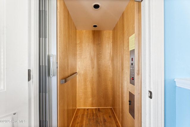 room details featuring elevator and wood-type flooring