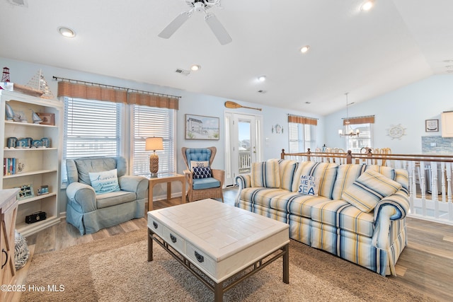 living room with visible vents, wood finished floors, ceiling fan with notable chandelier, vaulted ceiling, and recessed lighting