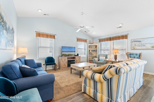 living room with visible vents, vaulted ceiling, and wood finished floors