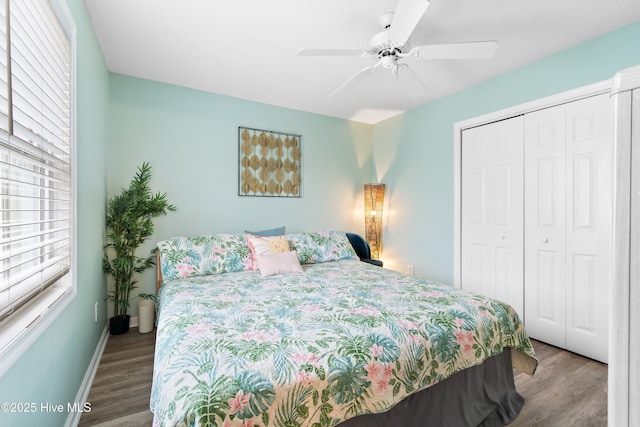 bedroom with a closet, wood finished floors, a ceiling fan, and baseboards