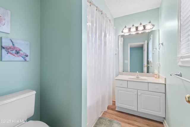 full bathroom with a shower with shower curtain, toilet, wood finished floors, a textured ceiling, and vanity