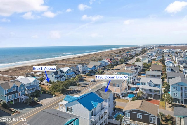 drone / aerial view with a residential view, a water view, and a beach view