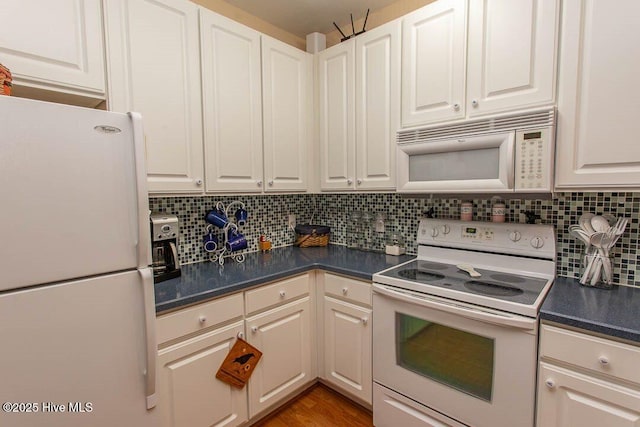 kitchen featuring hardwood / wood-style floors, white appliances, decorative backsplash, and white cabinets