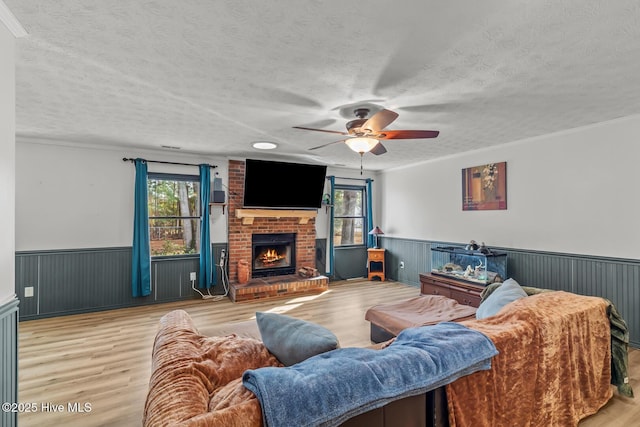 living room with a brick fireplace, a textured ceiling, and a healthy amount of sunlight