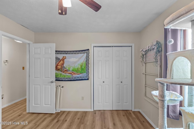 bedroom featuring ceiling fan, light hardwood / wood-style floors, and a closet