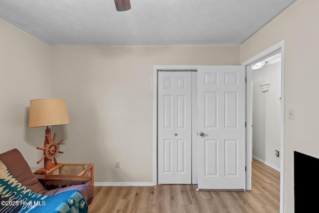 sitting room featuring light hardwood / wood-style floors and a textured ceiling