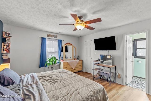 bedroom featuring ceiling fan, a textured ceiling, and light wood-type flooring