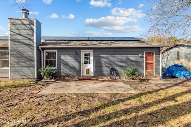 rear view of house with a patio and solar panels