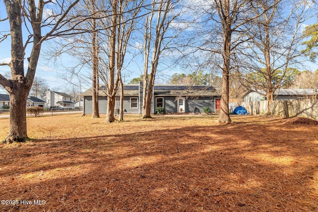 rear view of property featuring a lawn