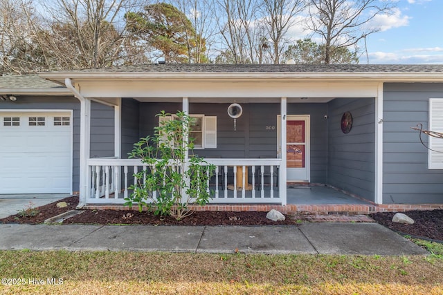 view of exterior entry featuring a garage and covered porch