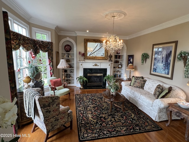 living room featuring hardwood / wood-style flooring, ornamental molding, built in features, and a premium fireplace