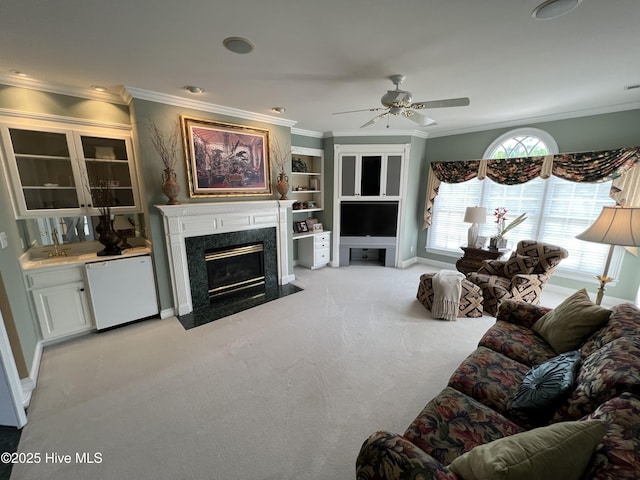 living room featuring ornamental molding, light colored carpet, ceiling fan, and a high end fireplace